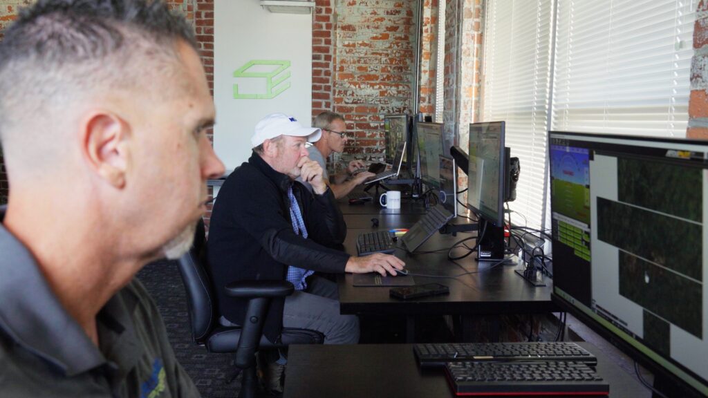 Group Of People Working On Laptops At A Desk